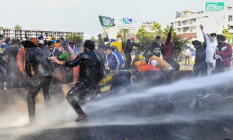Police personnel use water canons on farmers to stop them from crossing the Punjab-Haryana border during 'Delhi Chalo' protest march against the new farm laws, near Ambala. (Photo | PTI)