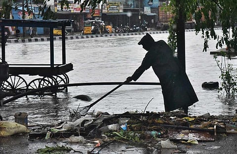 A corporation worker clearing the garbage for the free flow of flood Satyamurthy Nagar Thiruvatriyur following Nivar' on Wednesday in Chennai. (Photo | P Jawahar, EPS)