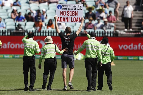 Security lead a protester from the field after he interrupted the one day international cricket match between India and Australia at the Sydney Cricket Ground. (Photo | AP)