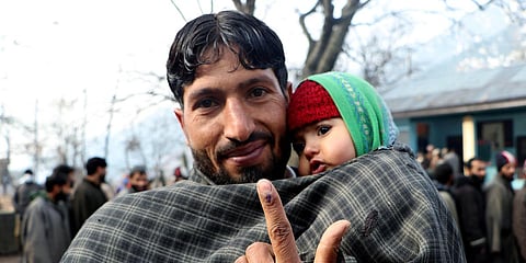 A man shows his inked finger after casting his vote for the first phase of District Development Council elections, in Srinagar. (Photo| ANI)
