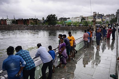 Saidapet locals gather to see the rising water levels in Adyar river after gates of Chembarambakkam lake were opened after heavy rains. (Photo | Debadatta Mallick, EPS)