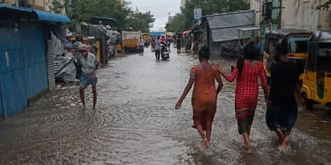 People walk through a flooded street in Chennai. (Photo by special arrangement)