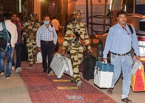 Security personnel and polling officers carry EVMs to deposit at a strong room after the second phase of Bihar Assembly polls in Patna Tuesday Nov. 3 2020. (Photo | PTI)