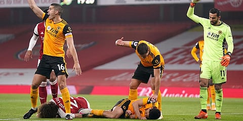 Players gesture to medical staff after a head clash between Arsenal's David Luiz, bottom left, and Wolverhampton Wanderers' Raul Jimenez during the EPL match at Emirates Stadium. (Photo | AP)