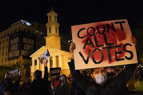 A demonstrator holds up a sign while waiting for election results at Black Lives Matter Plaza, Tuesday, Nov. 3, 2020, in Washington. (Photo | AP)