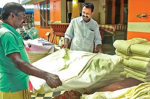 M Vincent, MLA, looking at the handloom products of a weaver at Balaramapuram