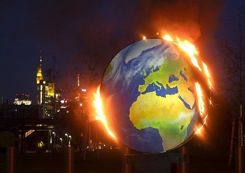 A makeshift globe burns in front of the European Central Bank in Frankfurt, Germany. (Photo | AP)