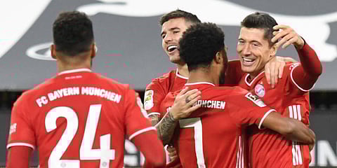 Bayern Munich striker Robert Lewandowski (R) celebrates after scoring his side's second goal during the German Bundesliga match against Borussia Dortmund. (Photo | AP)