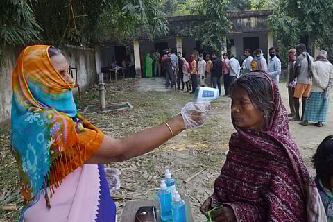 Voters undergo temperature check at poll stations. (Photo| PTI)