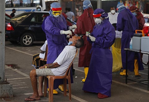 Sri Lankan health workers take a swab sample from a man to test for COVID-19 in Colombo, Sri Lanka. (Photo | AP)