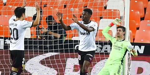 Real Madrid's goalkeeper Thibaut Courtois reacts as Valencia players celebrate a goal. (Photo | AP)