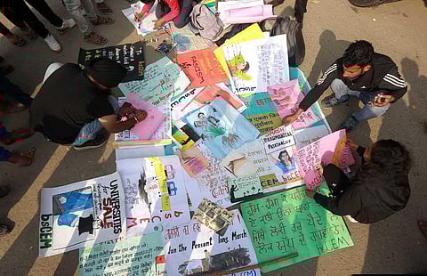 Youngsters design posters at Singhu border during ongoing farmers' protest march 'Delhi Chalo' on Tuesday. (Photo | Shekhar Yadav, EPS