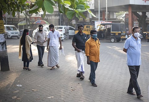 People wearing masks as a precaution against the coronavirus queue up to vote for local elections in Kochi, Kerala. (Photo | AP)