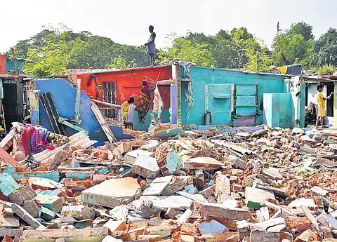 Residents linger around the remains of their houses on day two of the slum eviction drive at Sathyavani Muthu Nagar, near Island Grounds, in Chennai on Thursday | R Satish Babu