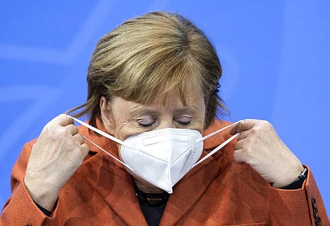 Germany Chancellor Angela Merkel adjusts her mask and comments on the further procedure in the Corona crisis at a press conference. (Photo | AP)