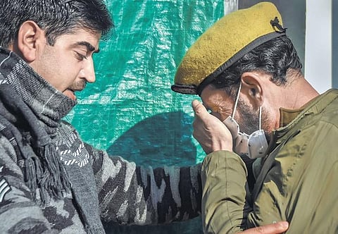 A man consoles a policeman as his colleague succumbed to injuries after a militant attack, in Srinagar. (Photo | PTI)