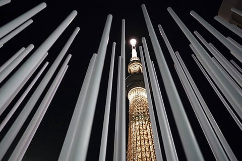 The Tokyo Skytree, the tallest tower in Japan, is illuminated with the color of the Olympic Torch, to commemorate 100 days until the torch relay begins. (Photo | AP)