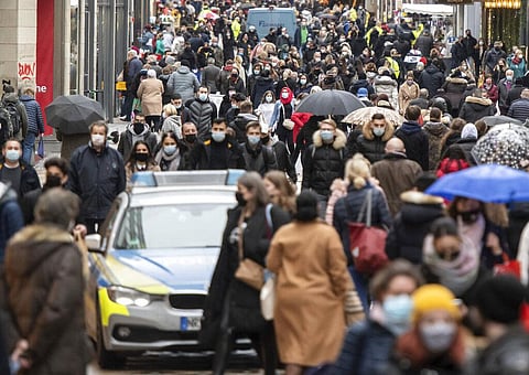 A police patrol car wades through people along the Westenhellweg shopping street, in Dortmund, Germany. (Photo | AP)
