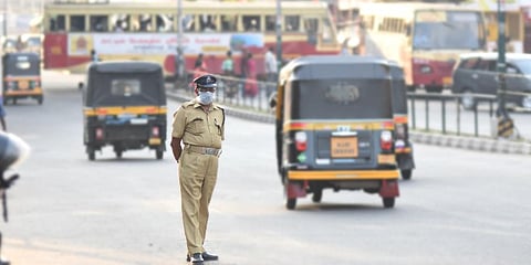 A Home Guard donning a face mask managing traffic in front of Thampanoor Bus Stand in Thiruvananthapuram. (Photo | BP Deepu, EPS)