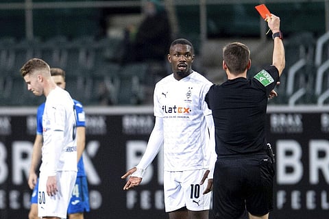 Referee Frank Willenborg shows Moenchengladbach's Marcus Thuram the red card during their German Bundesliga soccer match between Borussia Moenchengladbach and 1899 Hoffenheim. (Photo | AP)