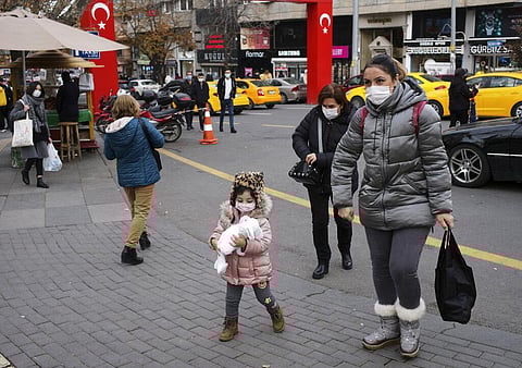 People wearing face masks to protect against coronavirus, walk along a street hours before a two-day weekend curfew, in Ankara, Turkey, Friday, Dec. 18, 2020. (Photo | AP)