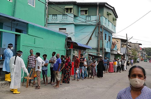 People queue up to give their swab samples to get tested for COVID-19 in a residential neighborhood in Colombo. (Photo | AP)