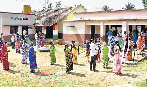 Voters maintain social distance to cast their votes in Hosa Ramanahalli. (Photo| EPS)