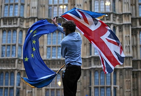 In this file photo taken on June 28, 2016 a man waves both a Union flag and a European flag together on College Green outside The Houses of Parliament, London. (Photo | AFP)
