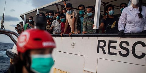 Migrants from different nationalities weraing masks at a Spanish shore. (Photo | AP)