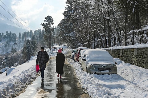 eople walk down a road after fresh snowfall at Tangmarg in Baramulla District of north Kashmir, Tuesday, Dec. 29, 2020. (Photo | PTI)