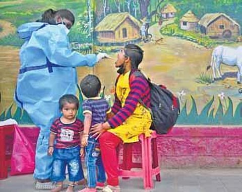 A health worker takes a swab sample from a passenger at Majestic Bust Stand, Bengaluru, on Monday | Ashish Krishna HP