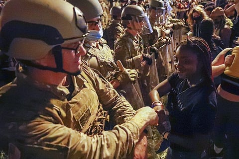 A Utah National Guard soldier fist-bumps with a demonstrator as protests over the death of George Floyd continue, Wednesday, June 3, 2020. (Photo | AP)