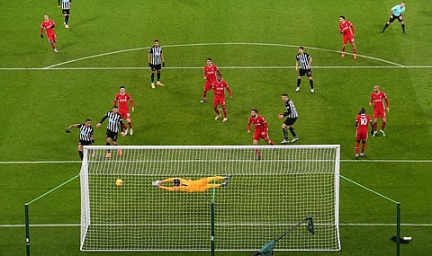 Liverpool's Brazilian goalkeeper Alisson Becker svaes an attempt from Newcastle United's Irish defender Ciaran Clark during the English Premier League football match. (Photo | AFP)