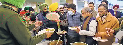 Union Agriculture Minister Narendra Singh Tomar, Railway Minister Piyush Goyal and MoS for Commerce Som Prakash have food served by farmers during a snack break at a meeting over new farm laws, at Vig