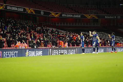 Fans applaud as the teams enter the pitch for the Europa League group B soccer match between Arsenal and Rapid Wien at Emirates stadium in London.(Photo | AP)