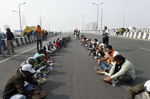 Farmers have 'langar' during ther protest at Delhi-UP border over Centre's farm reform laws on Friday. (Photo | PTI)