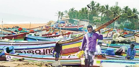 Fishermen carrying a catamaran after fishing activities were banned in anticipation of Cyclone Burevi