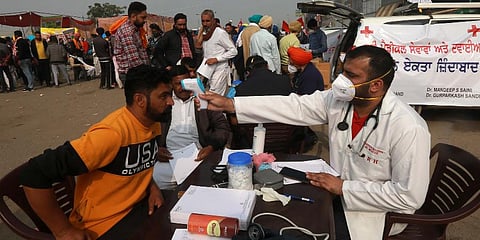Medical personnel check temperature for protestors during farmers protest at Singhu border in New Delhi on Saturday. (Photo | Shekhar Yadav, EPS)
