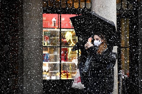 A woman wearing a face mask takes a photo on her phone in Covent Garden, London. (Photo | AP)