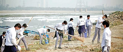 Schoolchildren participate in ‘Swachh Yamuna Bank Abhiyan’ campaign launched last year; toxic foam floats on the Yamuna in Kalindi Kunj. (Photo | EPS)