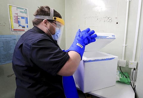 A pharmacy technician from Croydon Health Services prepares to store the first delivery of COVID-19 vaccine. (Photo | AP)