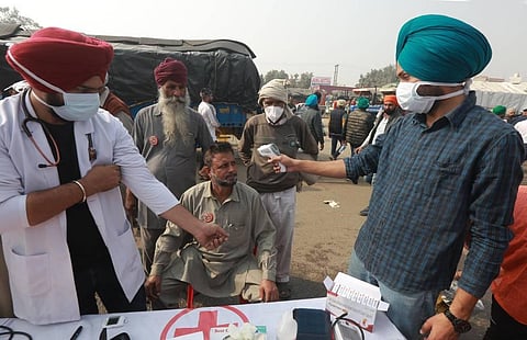 Medical personnel check temperature for protestors during farmers protest at Singhu border in New Delhi on Saturday. (Photo | Shekhar Yadav/EPS)