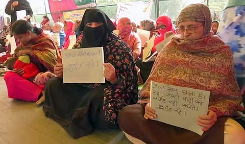 Demonstrators hold placards during a silent protest against CAA, NPR and NRC at Shaheen Bagh in New Delhi. (Photo | ANI)