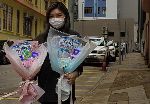 Flower shop owner Iris Leung wears her protective face mask as she delivers flowers with masks to customers on Valentine's Day in Hong Kong. (Photo | AP)
