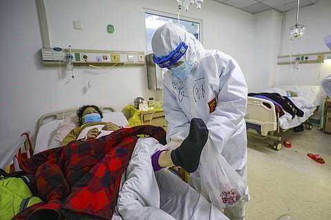 A doctor checks the conditions of a patient in Jinyintan Hospital, designated for critical COVID-19 patients, in Wuhan. (Photo | AP)