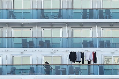 A passenger stands on a balcony onboard the quarantined Diamond Princess cruise ship at Daikoku Pier Cruise Terminal in Yokohama. (Photo | AFP)