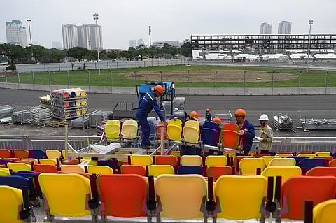 Workers carry chairs for the grandstand of the under-construction Formula One Vietnam Grand Prix race track site in Hanoi. (Photo| AFP)