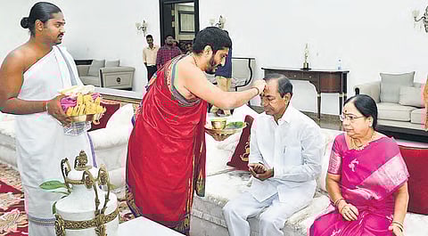 A priest blesses Chief Minister K Chandrasekhar Rao on his 66th birthday as his wife looks on