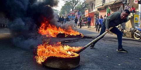 A demonstrator burns tyres on National Highway 17 during a protest rally against CAB at Boko in Kamrup district of Assam. (File | PTI)