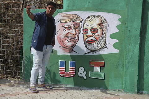 A man takes a selfie with portraits of US President Donald Trump and Indian Prime Minister Narendra Modi painted on a wall ahead of Trump's visit, in Gujarat's Ahmadabad. (Photo | AP)